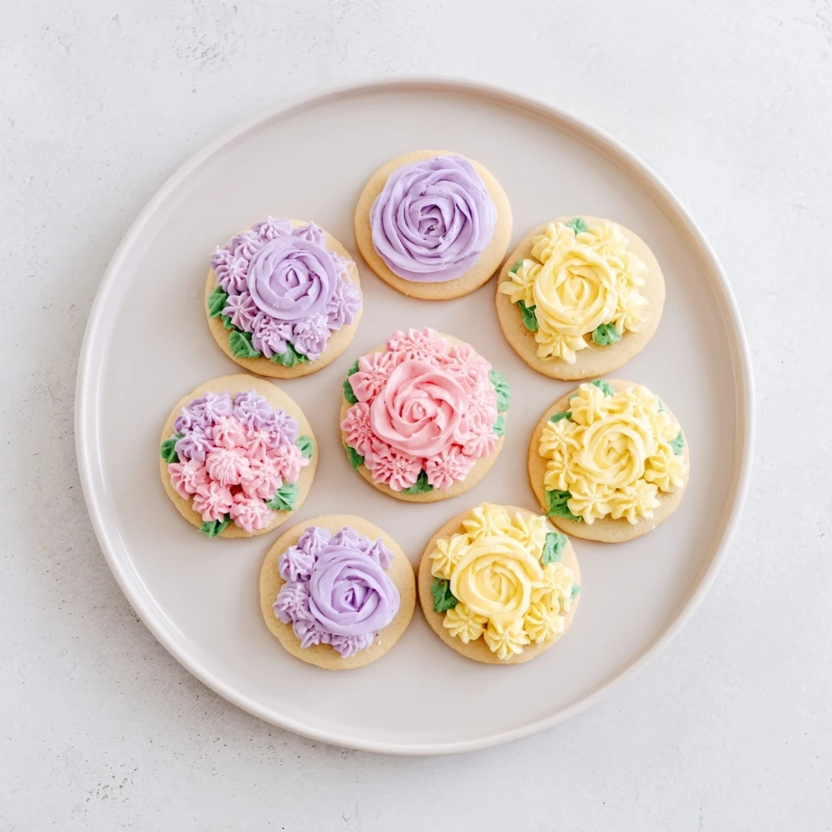 Decorated buttercream flower cookies showcasing vibrant piped floral designs atop soft sugar cookies