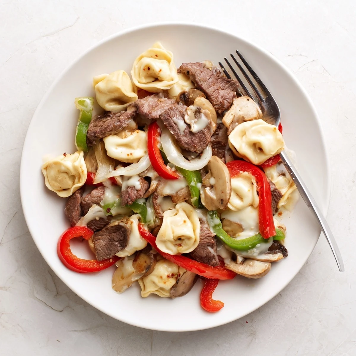 Hearty bowl of Crock Pot cheesesteak tortellini loaded with cheesy tortellini and sautéed vegetables