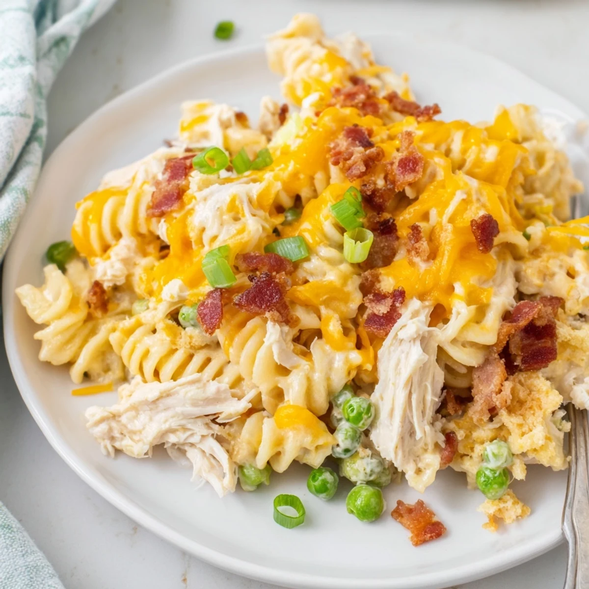 Creamy Crock Pot crack chicken casserole topped with melted cheddar and crispy bacon crumbles