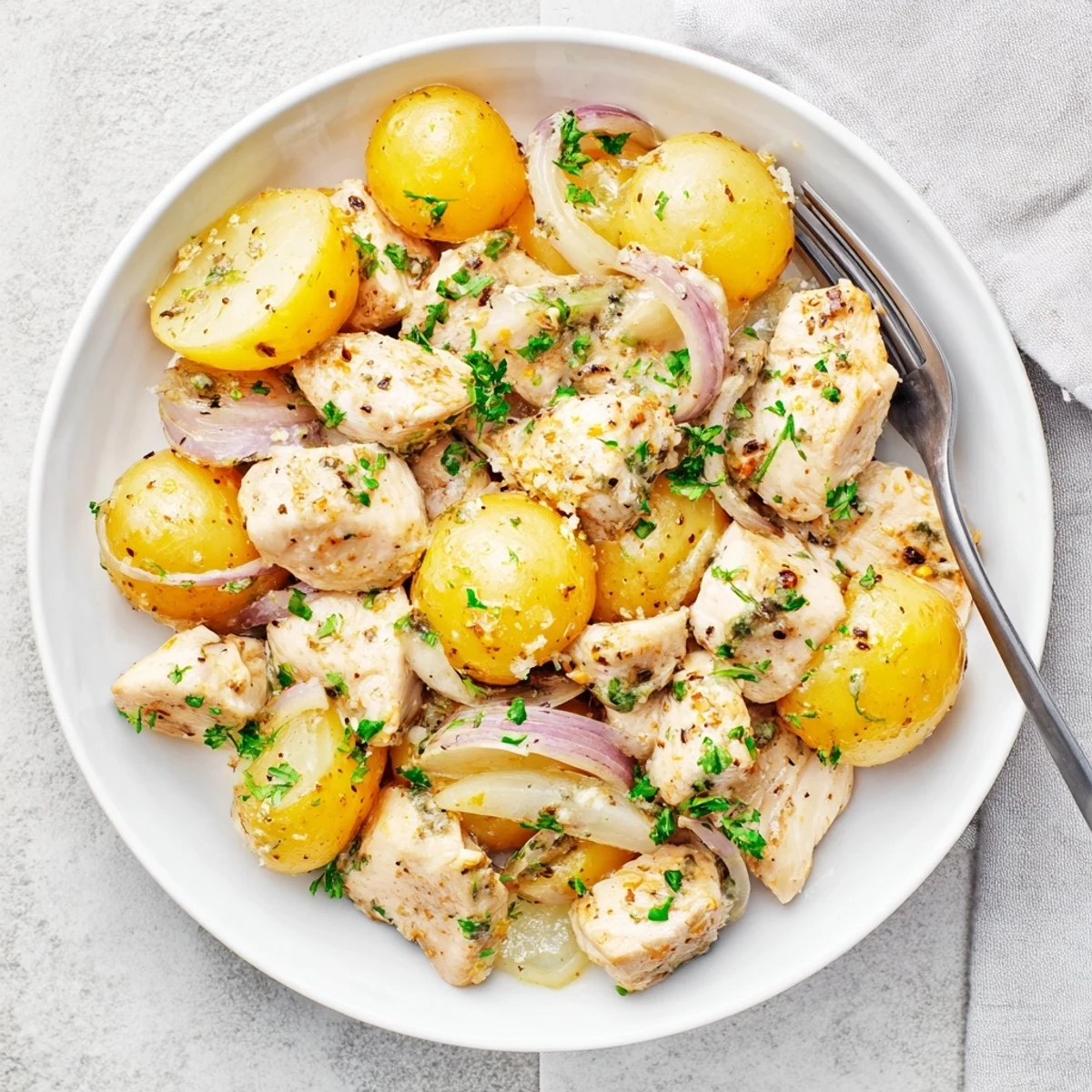 Tender one-pot garlic Parmesan chicken and potatoes slow-cooked with herbs and melted cheese for easy weeknight comfort