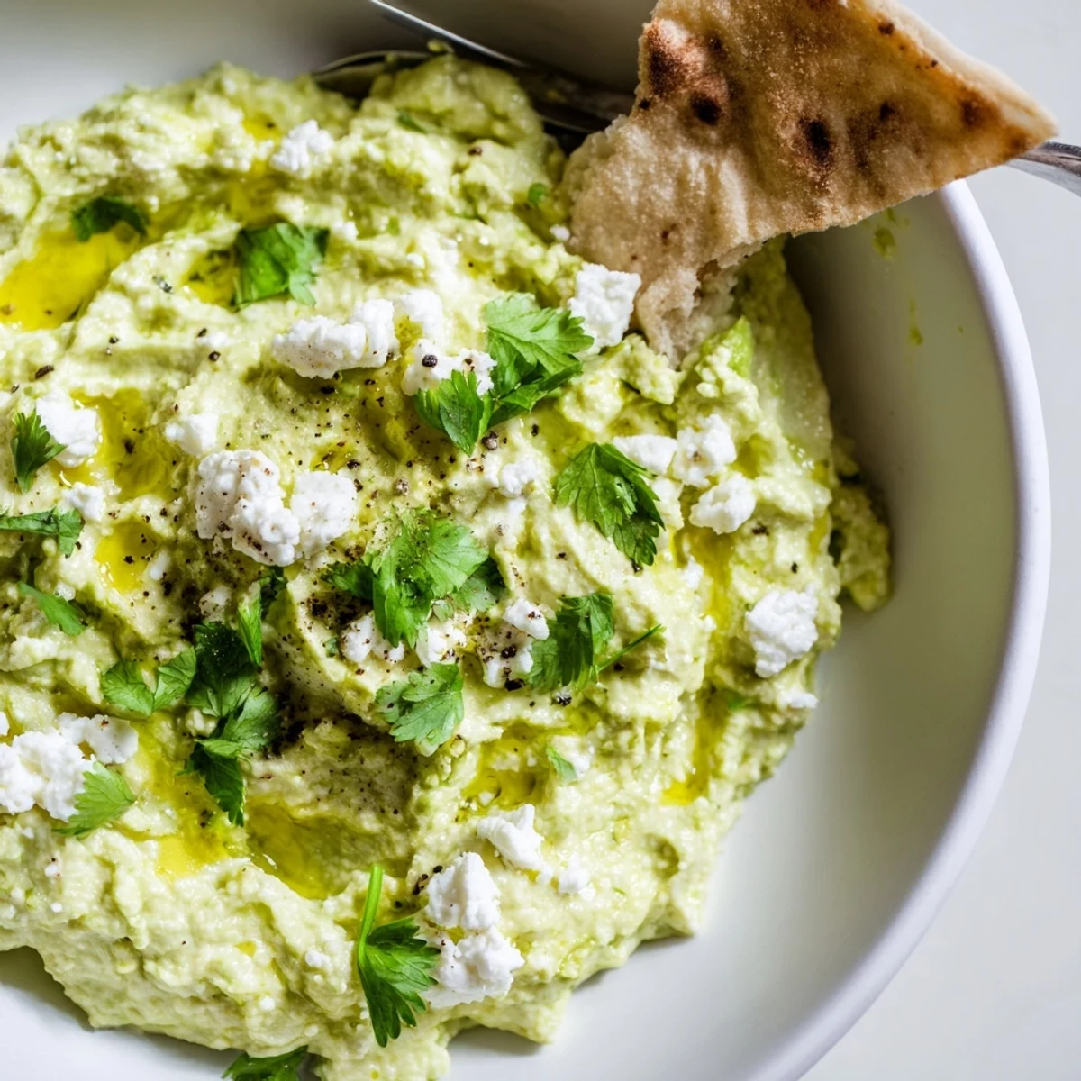 Creamy Avocado Feta Dip in bowl, silky texture, olive oil drizzle