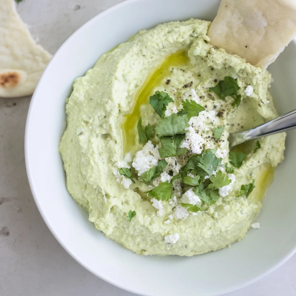 Smooth Creamy Avocado Feta Dip with lime brightness, pita chips nearby