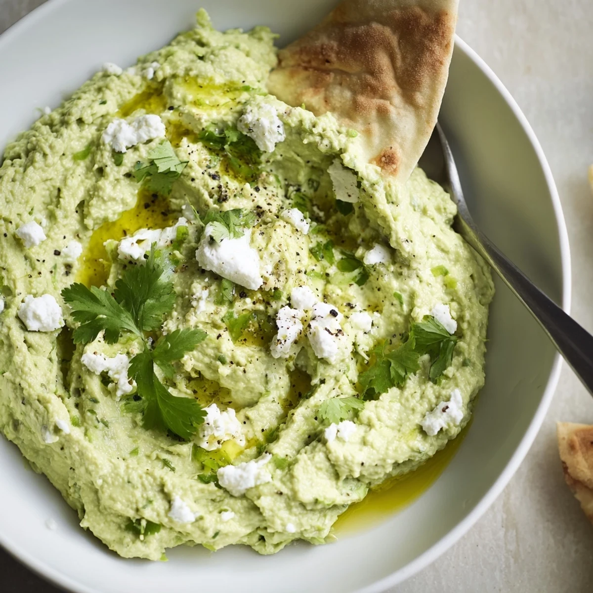 Party ready Creamy Avocado Feta Dip topped with crumbled feta and cilantro