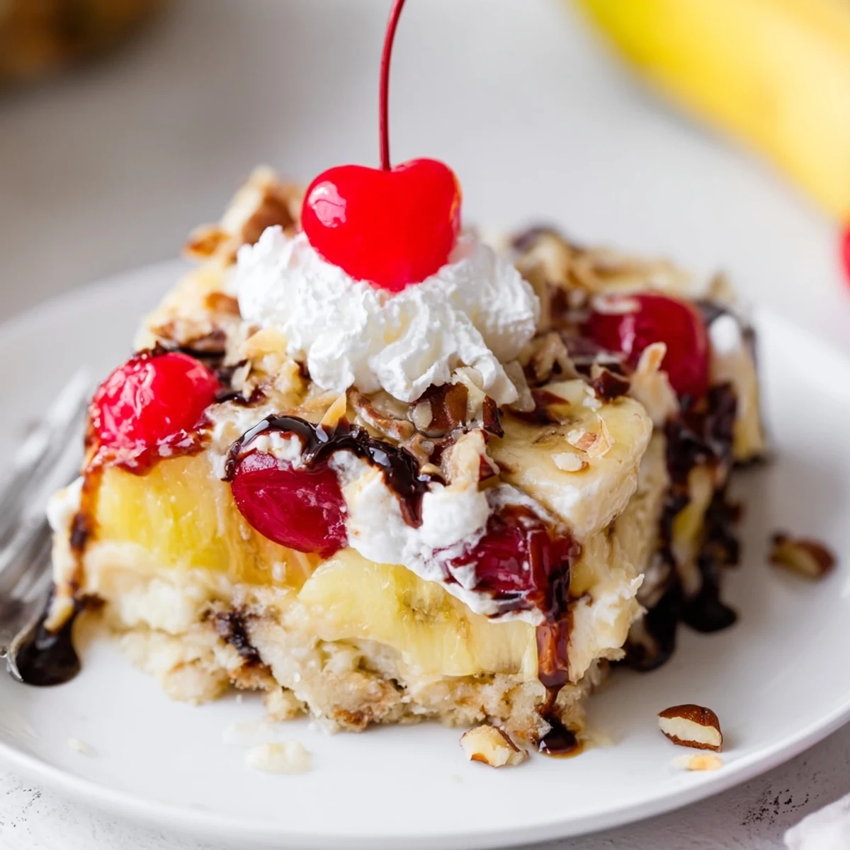 Slice of Banana Split Dump Cake topped with whipped cream and syrup