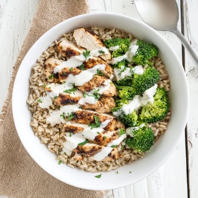 Nutritious grilled chicken broccoli bowl featuring tender spiced chicken, vibrant broccoli, and tangy garlic yogurt sauce ready for dinner